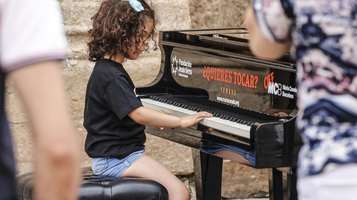 Vega, de 6 años, recorre cada uno de los ocho pianos desplegados en el casco histórico.