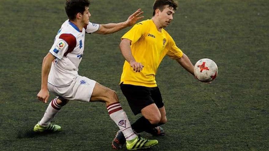 Dos jugadores del Roces y L&#039;Entregu pugnan por el balón.