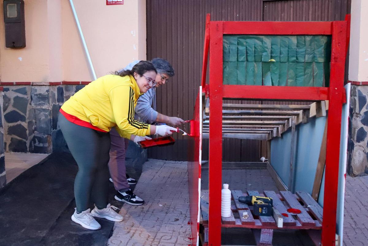 Juana y Lucía, vecinas de Sagrajas pintan una de las figuras decorativas de este año.