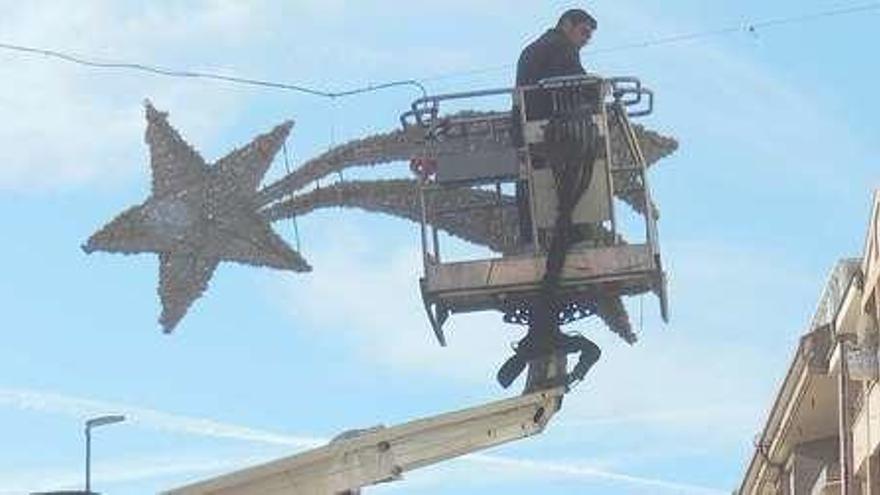 Operarios instalan guirnaldas navideñas en la avenida Maragatos de Benavente.