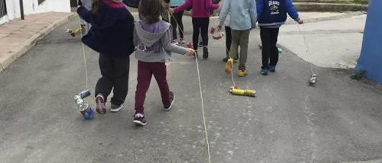 Niños de Almiserà arrastrando botes por las calles de la localidad para cumplir con la tradición de los «panderos».