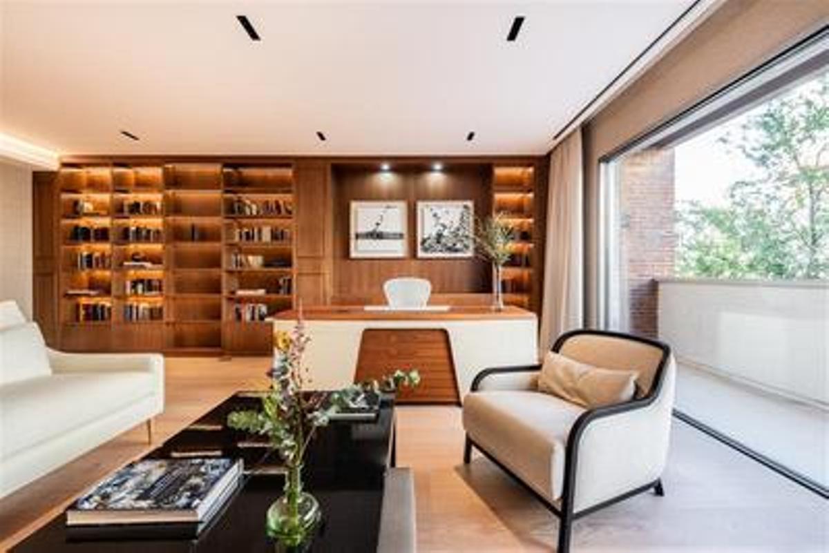 La vivienda cuenta con un despacho de gran tamaño con biblioteca (en la imagen), con un diseño exquisito y vistas preciosas a los edificios más clásicos del barrio de Los Jerónimos.