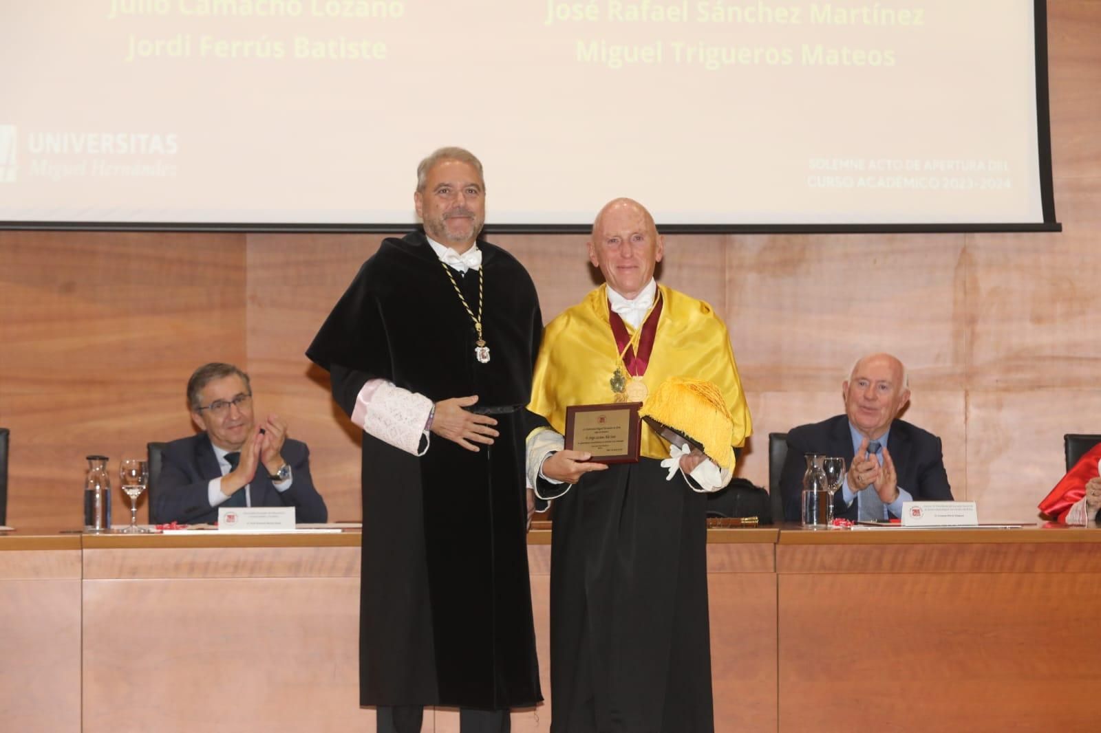 El conseller de Educación, José Antonio Rovira, aplaude tras la entrega, por parte del rector, de un reconocimiento.