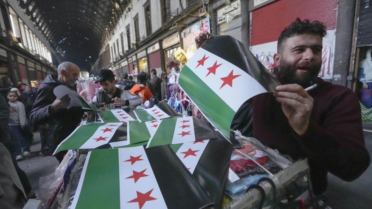 Un hombre vende banderas de la oposición rebelde siria en el mercado de Al Hamidiyeh, en Damasco, este martes.