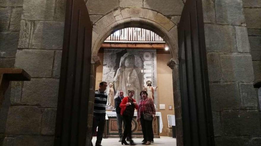 Un grupo de visitantes contempla la portada occidental de la iglesia de Santa Marta de Tera.