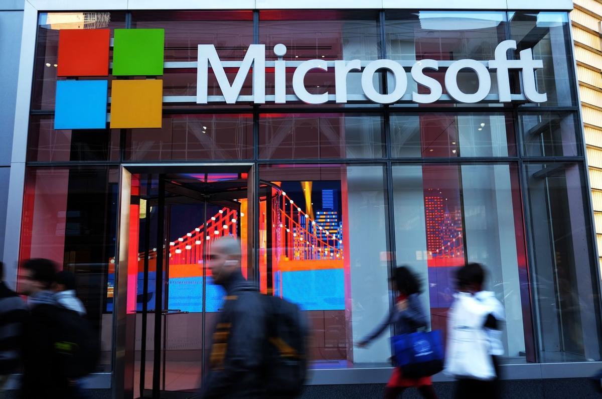 (FILES) This file photo taken on October 06, 2015 shows people walk past a Microsoft office in New York.