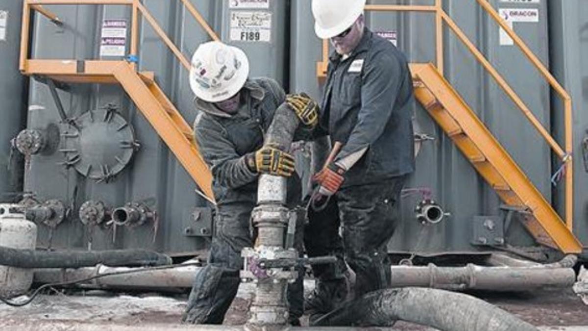 Dos operarios, en una planta de 'fracking' de Dakota del Norte.