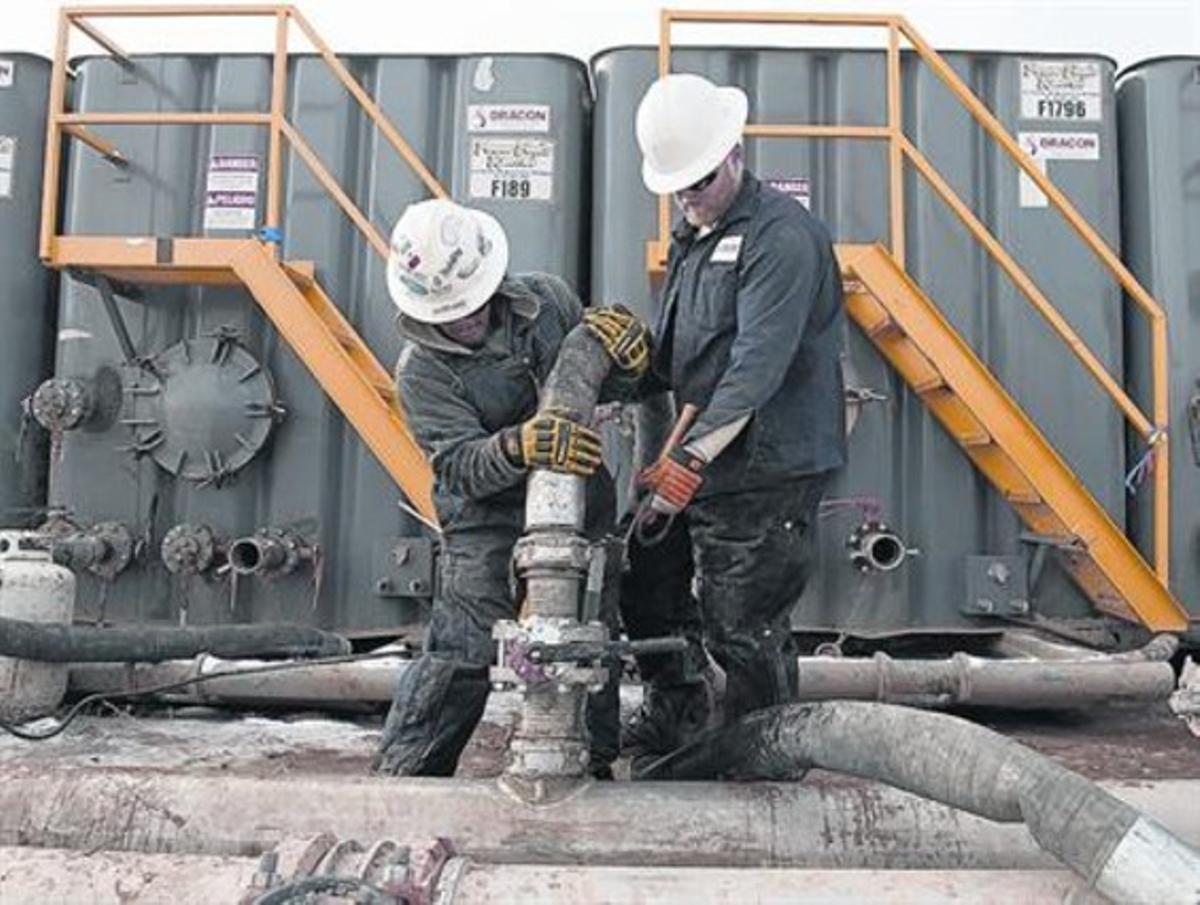 Dos operaris, en una planta de ’fracking’ de Dakota del Nord.