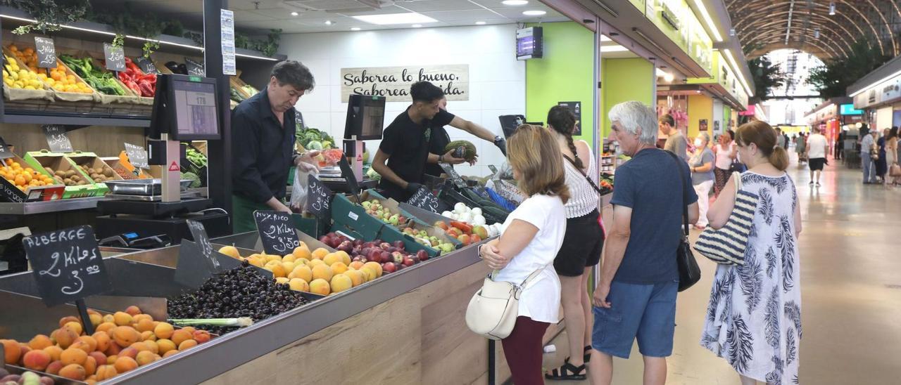 Varios ciudadanos compran fruta en un puesto del Mercado Central. | ÁNGEL DE CASTRO