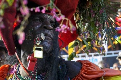 A man, with whistles and wearing a costume, takes part in the Jacmel Carnaval