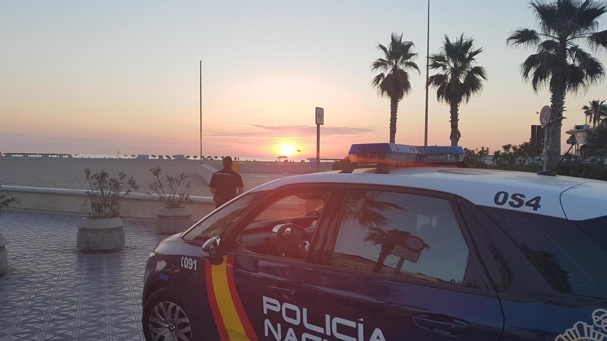 Un coche de la Policía Nacional en la playa de Gandia