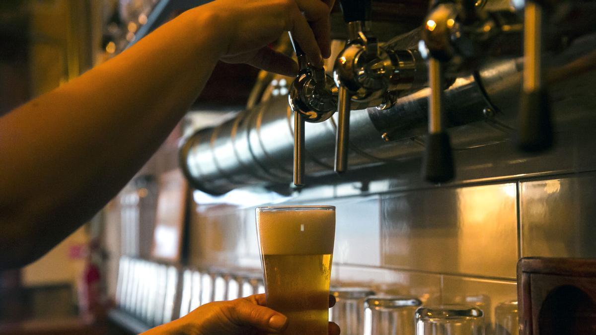 Un camarero sirve una cerveza en un establecimiento de ocio.