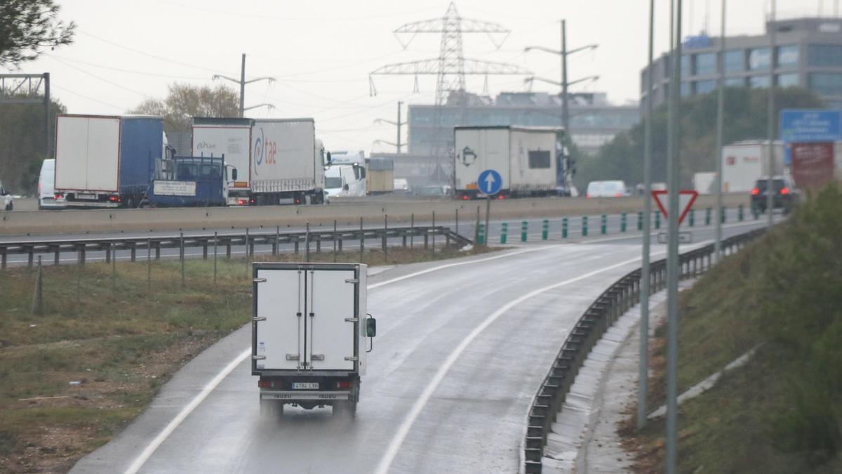 Un camió s'incorpora a l'autopista AP-7 en un dia de pluja.