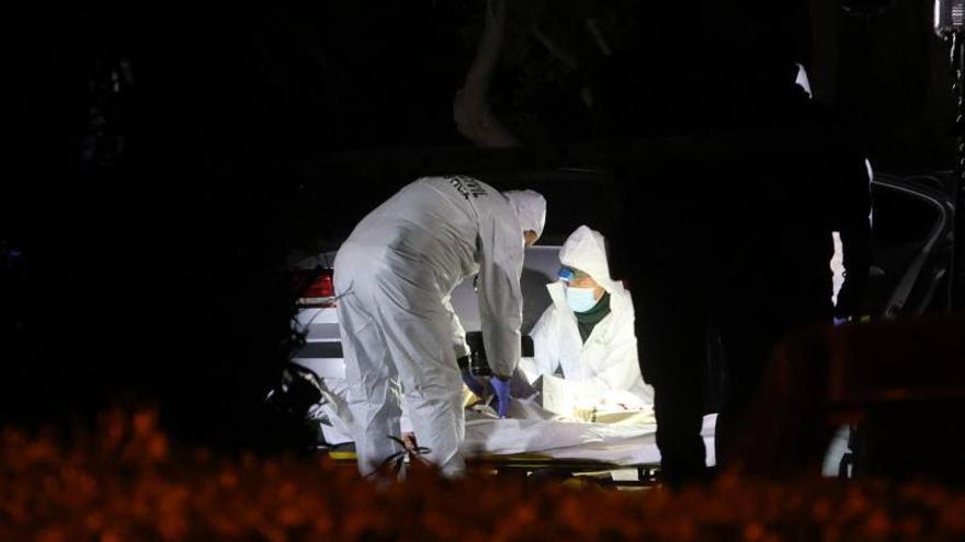 Agentes de Criminalística y el forense proceden al levantamiento de uno de los cadáveres del triple crimen del Saler
