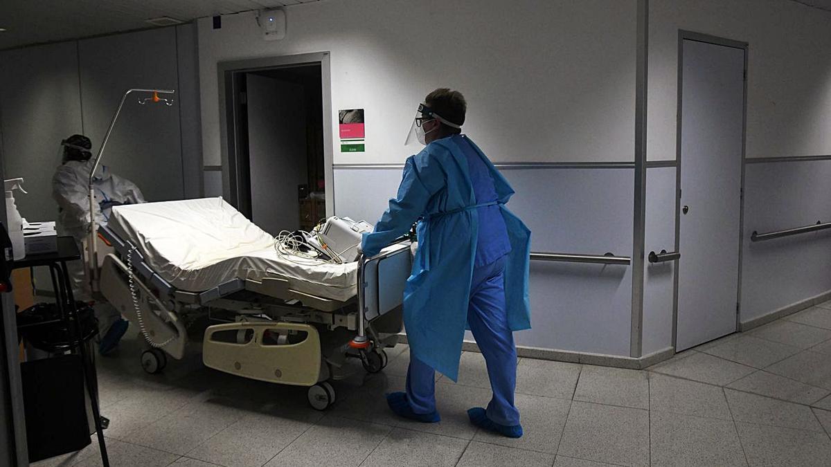 Sanitarios trasladan una cama por los pasillos de un hospital.