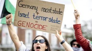 Una mujer muestra un cartel contra Israel y Alemania en una protesta frente al Tribunal Internacional de Justicia, este lunes en La Haya.