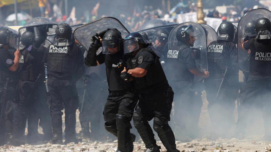 Un policía socorre a un compañero durante una protesta en Buenos Aires