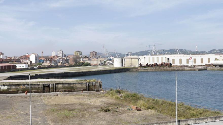 Terrenos públicos en Naval Gijón, partidos por el dique seco del antiguo astillero, con parte de las instalaciones colindantes del Tallerón de Duro Felguera al fondo, a la derecha. | ÁNGEL GONZÁLEZ