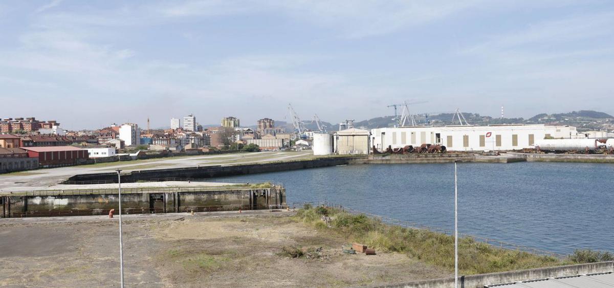 Terrenos públicos en Naval Gijón, partidos por el dique seco del antiguo astillero, con parte de las instalaciones colindantes del Tallerón de Duro Felguera al fondo, a la derecha. | ÁNGEL GONZÁLEZ
