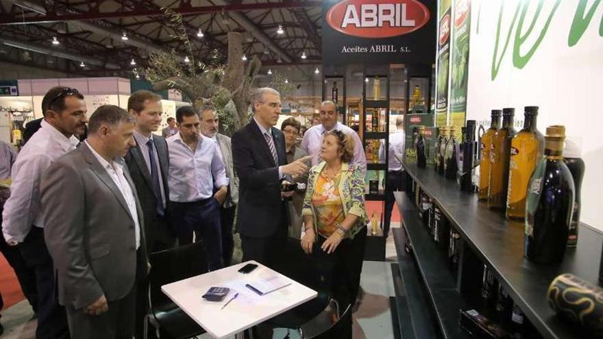 Arriba, Conde en un stand durante su recorrido por la feria. En la izquierda, los niños del CEIP de A bandeira, en un taller