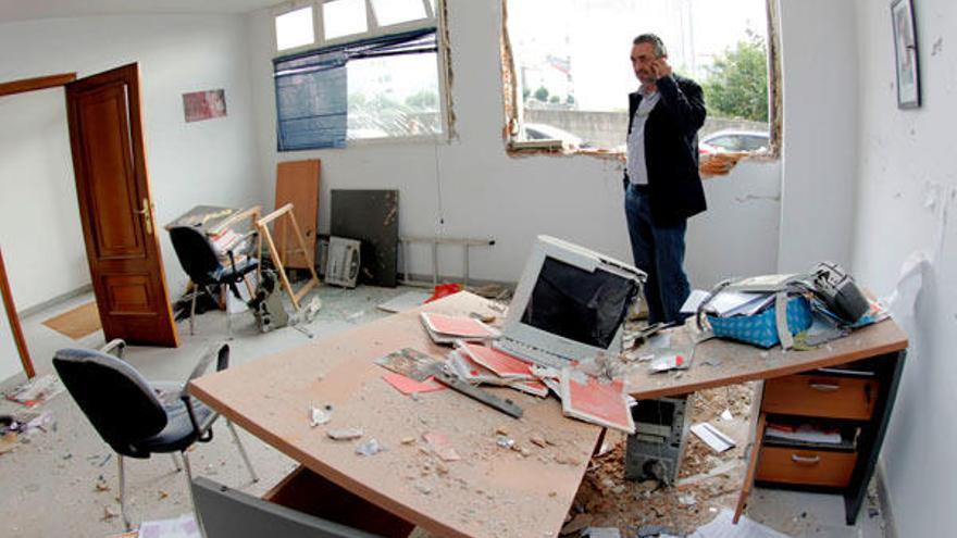 El alcalde de A Estrada (Pontevedra), José antonio Dono, observaba esta mañana los desperfectos en la sede del PSOE en dicha localidad pontevedresa, tras estallar anoche un artefacto que causó daños materiales en el edificio. // EFE