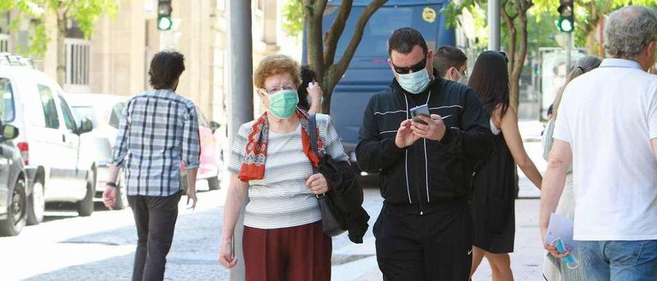 Viandantes con mascarilla en el centro de la ciudad de As Burgas. // Iñaki Osorio