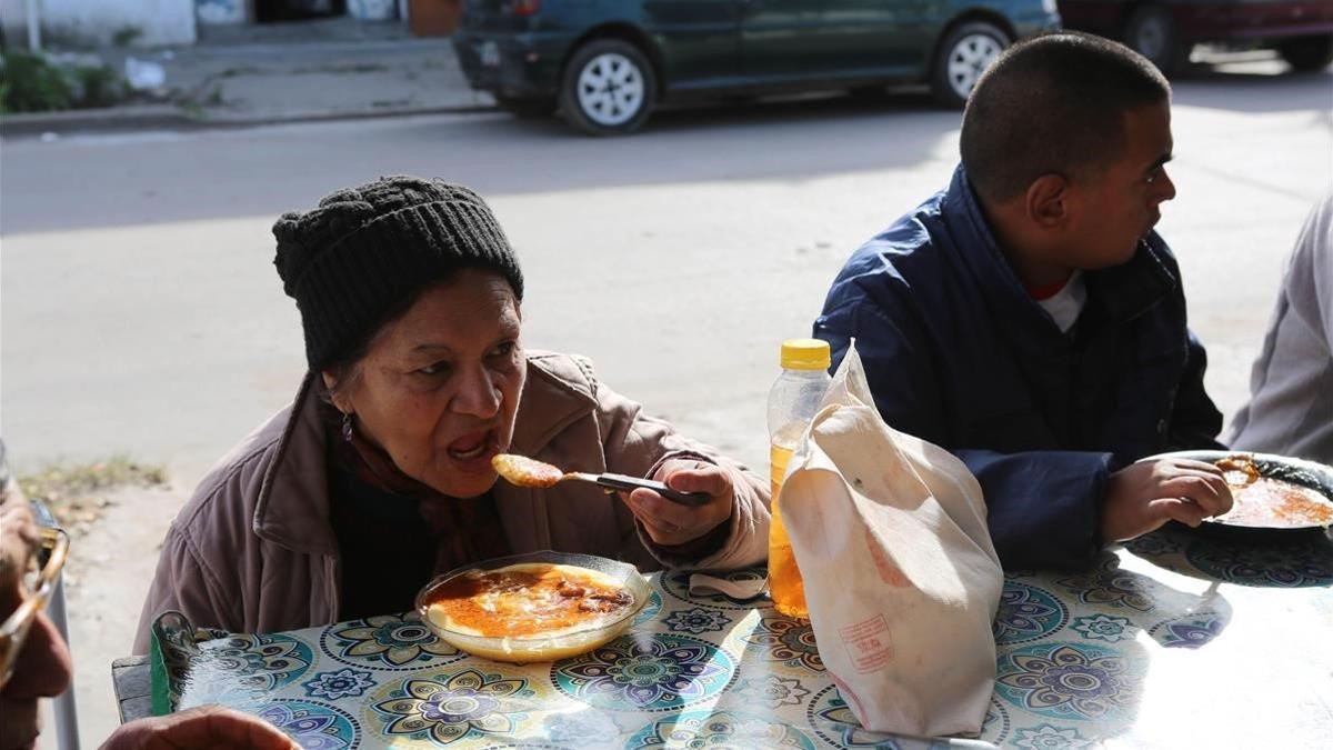 Una mujer y un hombre se alimentan en un comedor social de Villa Fiorito, en Buenos Aires, el pasado mes de junio.