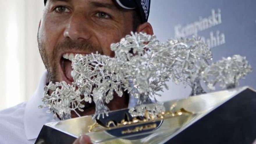 Sergio García muerde el trofeo de campeón del Andalucía Masters de golf. / eduardo abad / efe