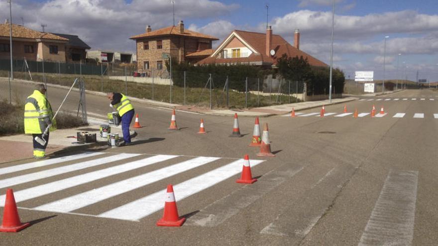 Operarios municipal repintan un paso de cebra en El Pinar.