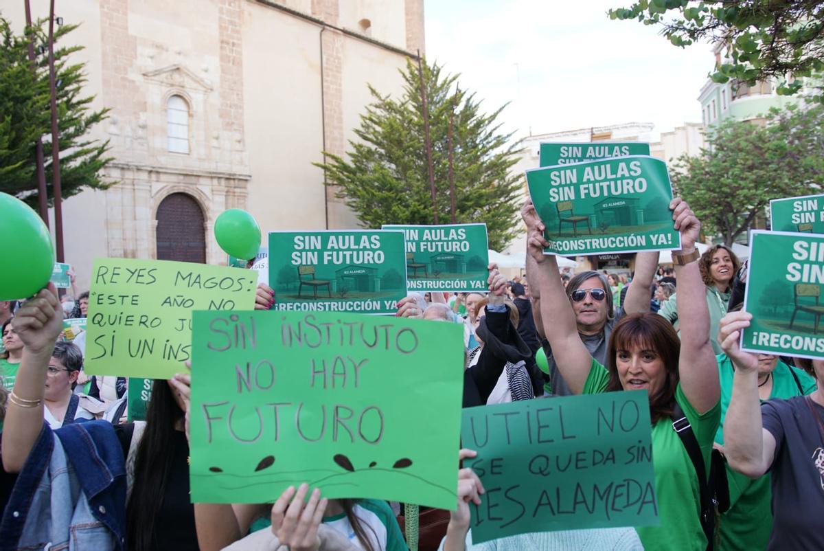 Los padres y madres exhibieron pancartas para exigir la reconstrucción.