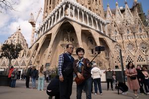 Archivo - Varios turistas se hacen fotos junto a la Sagrada Familia.