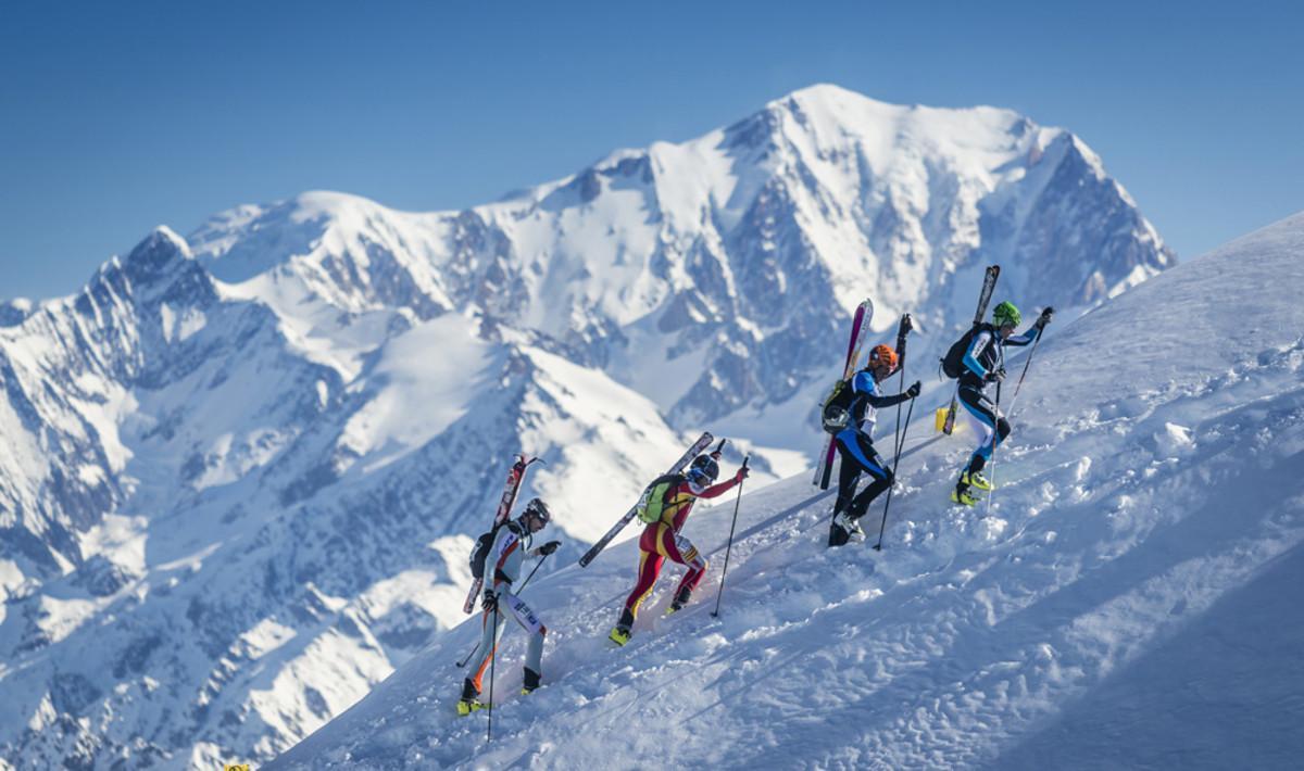 Un grupo de corredores asciende una montaña con el Mont Blanc de fondo, en la pasada Pierra Menta. 