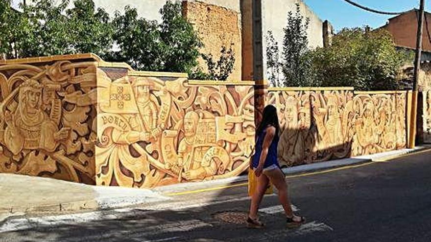 Una joven pasando al lado del mural de la Batalla de Toro.