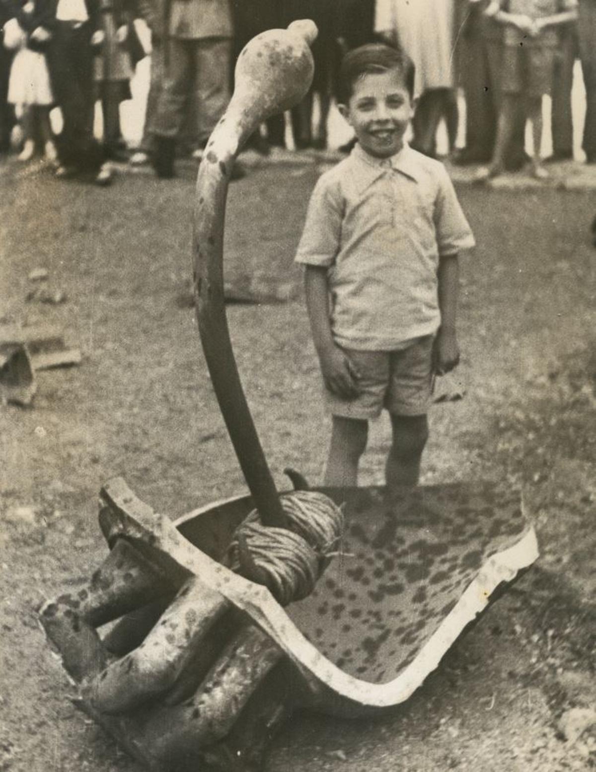 Un nen al costat d’un fragment de la campana, el dia de Corpus de l’any 1946 a Girona.