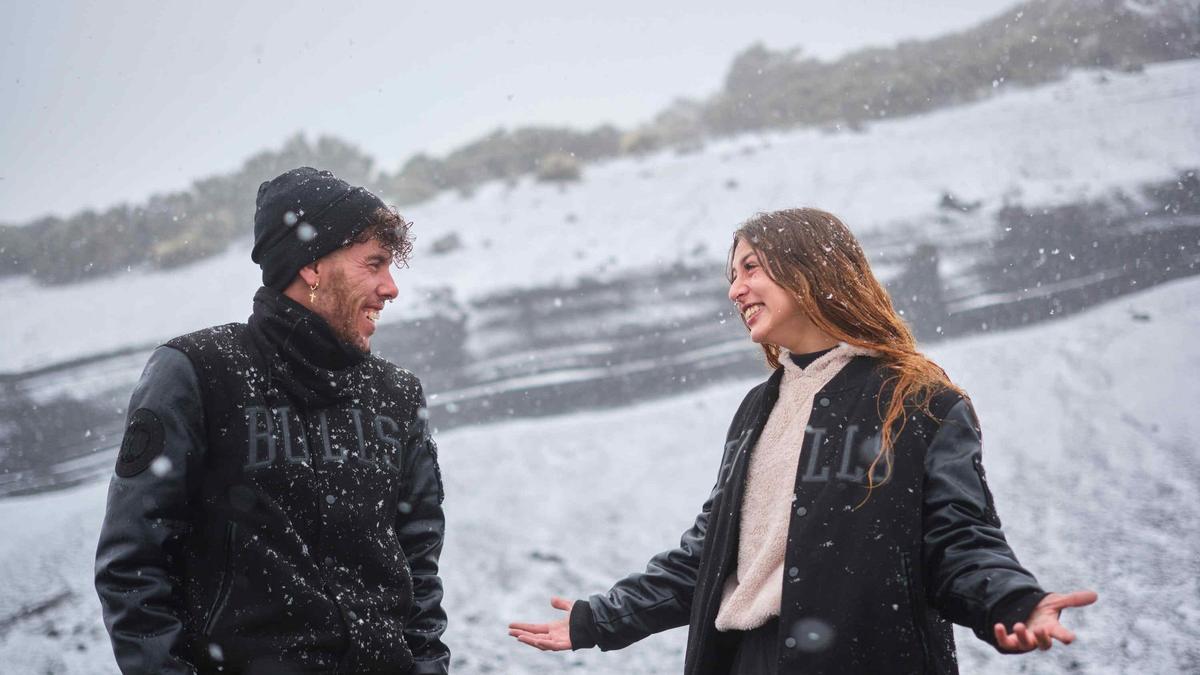 Una joven pareja disfruta de la nevada en el Teide.