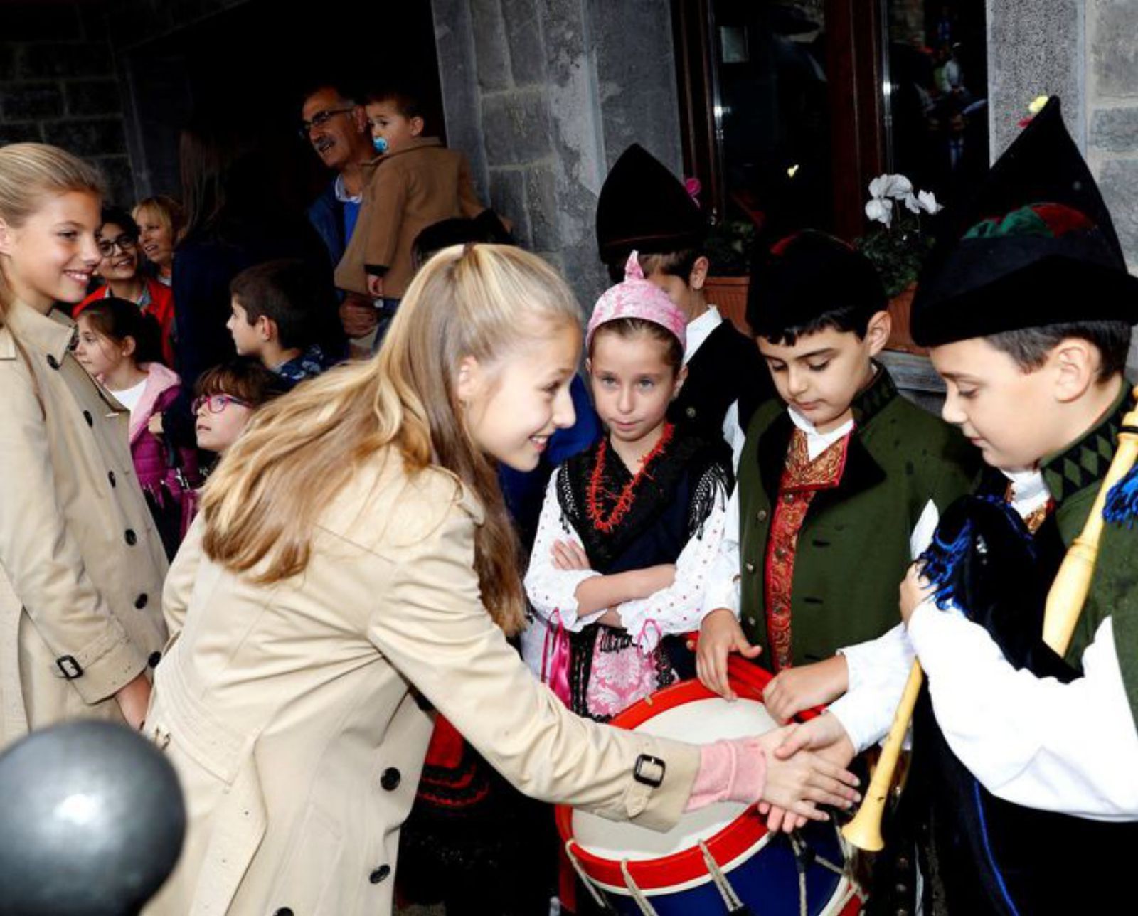 La Infanta Sofía y la Princesa Leonor, con los niños de un grupo de un grupo folclórico en Aseigu