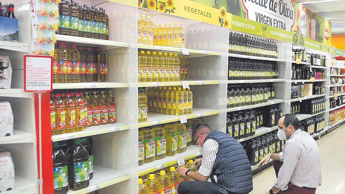 Profesionales trabajan con el aceite en un supermercado.