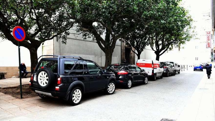 Cinco coches aparcados en espacio peatonal, en San Agustín, junto a una señal de estacionamiento prohibido.