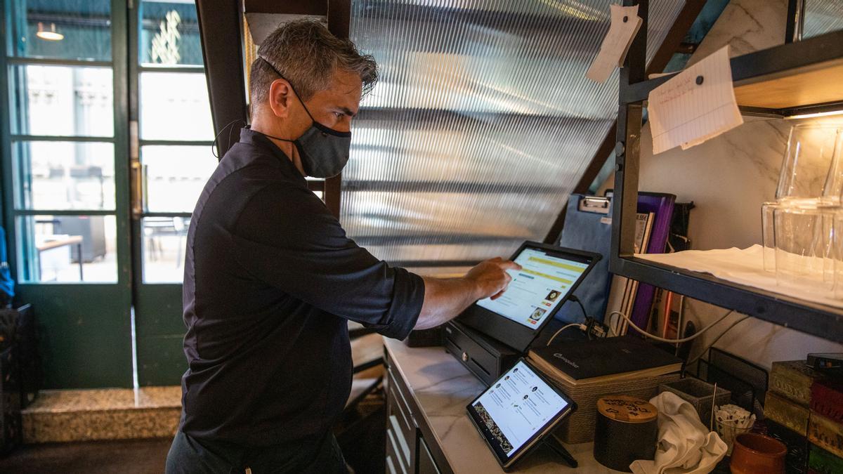 Joel, del restaurante Casa Amàlia, prepara la carta del día en el ordenador central para que se lea en su tablet e identifique la procedencia de los productos.