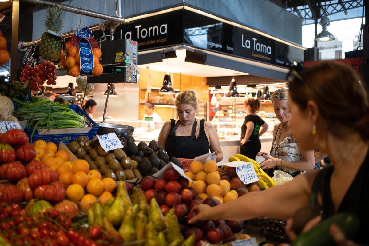 Una persona comprando fruta en el mercado de la Boquería, en Barcelona.