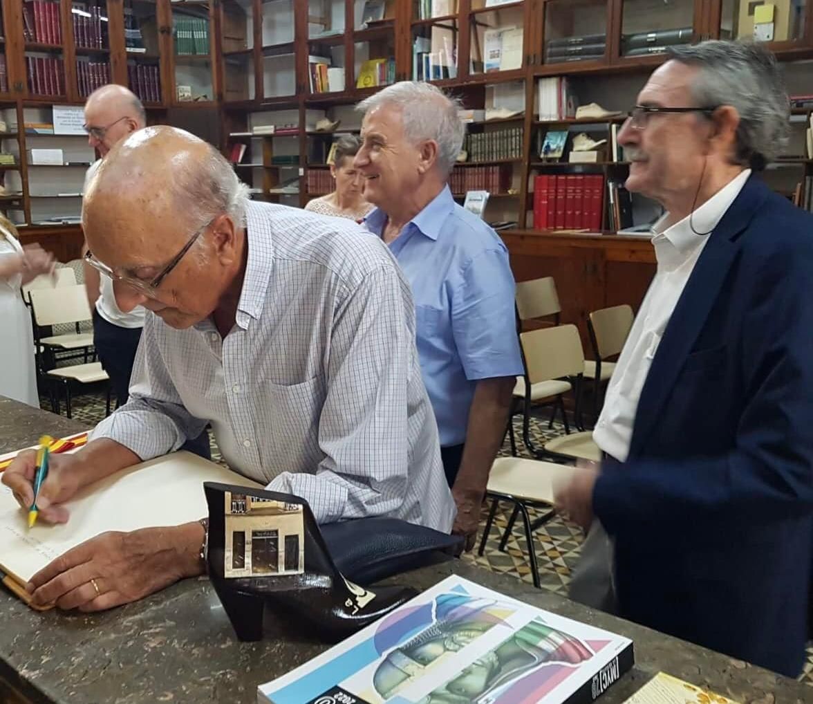 El arquitecto Manuel Serrano Bru firmando en el libro de honor de La Tertulia junto a Manolo Guill y Francis Valero.