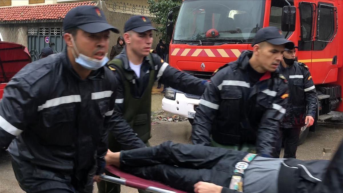 Trabajadores de emergencias evacuan a uno de los heridos en el taller textil clandestino de Tánger inundado por las fuertes lluvias, este lunes.