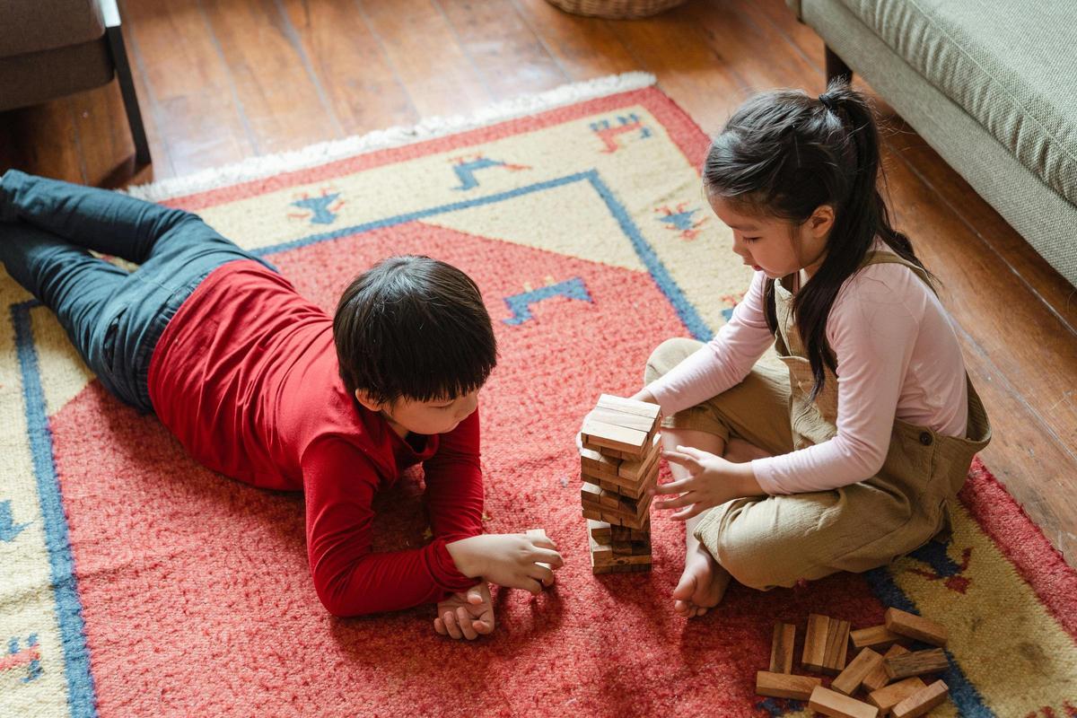 Dos niños juegan al famoso juego Jenga.