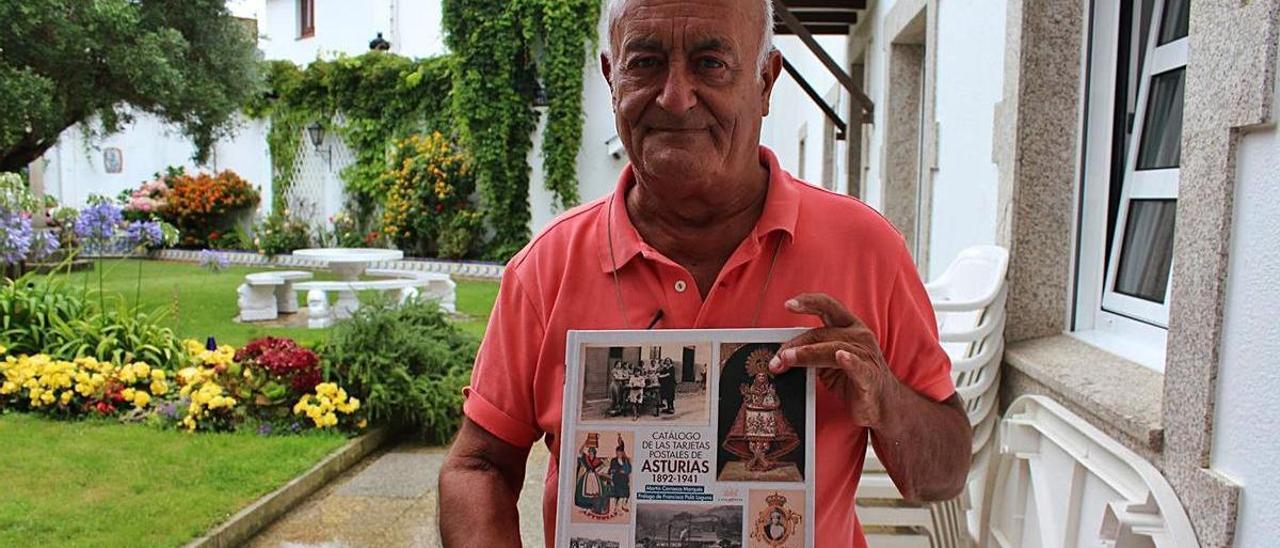 Martín Carrasco, en su casa de Tapia, con el catálogo de postales asturianas. | T. Cascudo