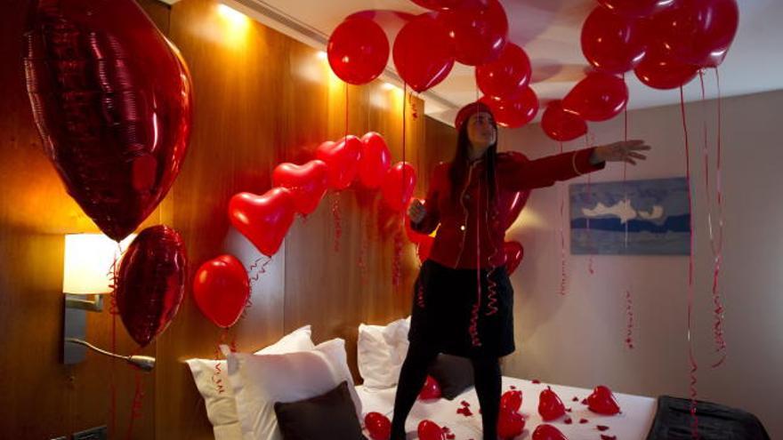 Una azafata en una de las habitaciones preparadas con decenas de globos en el suelo, mesas, cama y, hasta en el techo, para sorprender a la persona amada, una propuesta novedosa que invita a celebrar San Valentín en pareja.