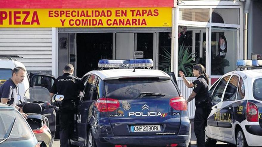 Efectivos de la Policía Nacional, ayer, en el bar junto a la gasolinera Shell de Altavista, donde se produjeron los hechos.