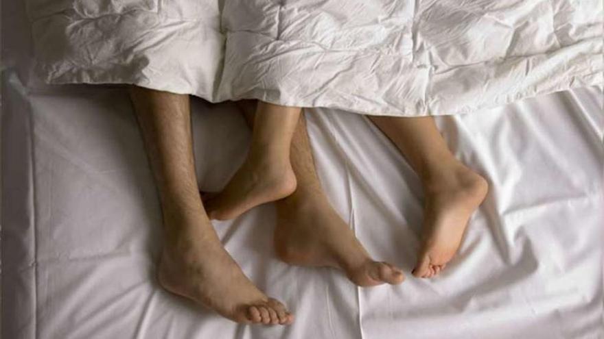 Las piernas de una pareja en la cama.