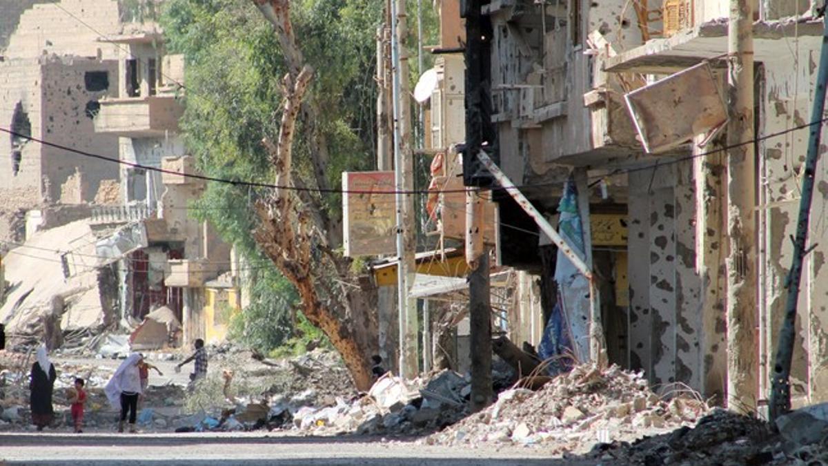 Ciudadanos sirios, en una dañada calle de Deir Ezzor.