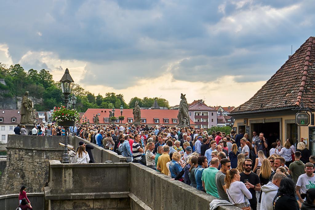 Cientos de personas se reúnen para tomar una copa de vino en el puente.