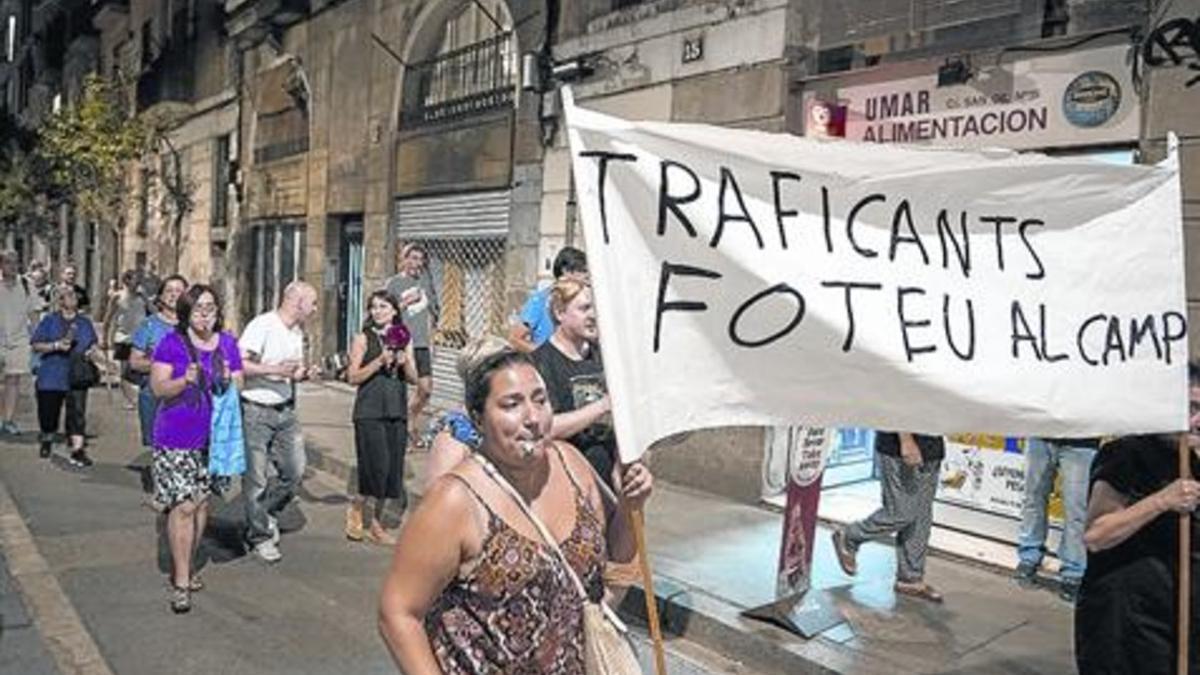 Cacerolada de los vecinos contra la presencia de traficantes en el Raval y miembros de la Guardia Urbana ante el número 18 de la calle de Sant Vicenç, donde han sido ocupados pisos.